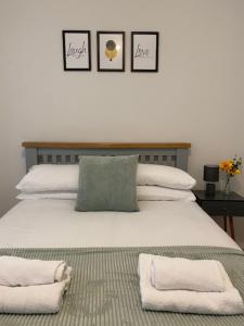 um quarto com uma cama grande e toalhas em Rodney Parade Mews em Newport