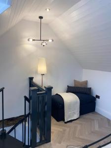 a attic bedroom with a bed and a ceiling at Modern finish to a historic brewers house, Derby in Derby
