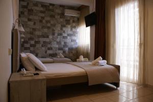 a bedroom with a bed and a brick wall at VARBENIS STUDIOS in Paralia Katerinis