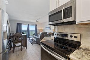 a kitchen with a stove top oven next to a living room at The Summit 621 in Panama City Beach