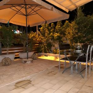 een tafel en stoelen onder een parasol op een patio bij Sp+P apartment in Alepou