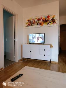un salon avec une télévision sur une commode dans l'établissement SAWADDEE, à Clermont-Ferrand