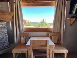 - une table et des chaises dans une chambre avec fenêtre dans l'établissement Cabaña Puma Tapalpa, à Tapalpa
