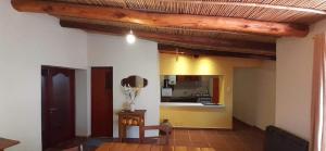 un soggiorno con cucina e una camera con tavolo di La casa del Norte a Humahuaca