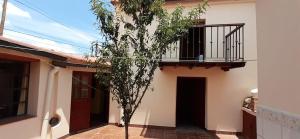 un piccolo albero di fronte a un edificio con balcone di La casa del Norte a Humahuaca