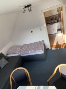 a small room with a bed and chairs and a kitchen at Kleine Wohnung "Freude" in Olsdorf