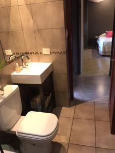 a bathroom with a toilet and a sink at Hermosa casa con pileta asador patio de fuego in San Salvador de Jujuy