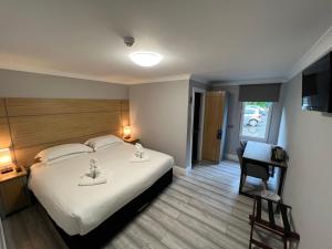 a bedroom with a bed and a desk and a chair at Auld Mill House Hotel in Dunfermline
