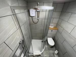 a small bathroom with a shower and a toilet at Auld Mill House Hotel in Dunfermline