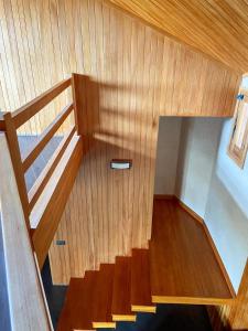 una escalera de madera en una casa con suelo de madera en Chalet Ermitage Oukaimeden en Oukkainrdem