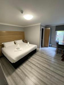 a bedroom with a large bed and a desk at Auld Mill House Hotel in Dunfermline