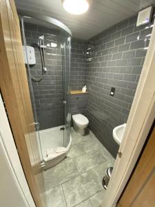 a bathroom with a glass shower and a toilet at Auld Mill House Hotel in Dunfermline