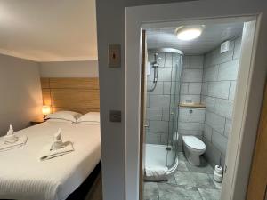 a bathroom with a bed and a shower and a toilet at Auld Mill House Hotel in Dunfermline
