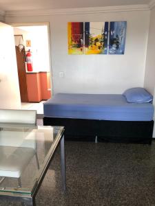 a bedroom with a blue bed and a glass table at APARTAMENTO EM NATAL III in Natal +48 photos