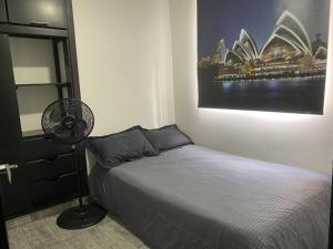 1 dormitorio con 1 cama y ventilador y la ópera Sydney en apartamento entero zona empresarial cali, en Cali