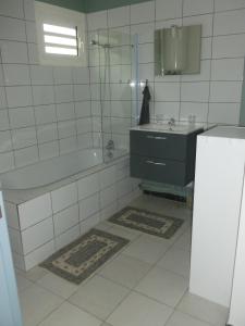La salle de bains est pourvue d'une baignoire, d'un lavabo et d'une baignoire. dans l'établissement Tropical Love, à Étang-Salé les Bains