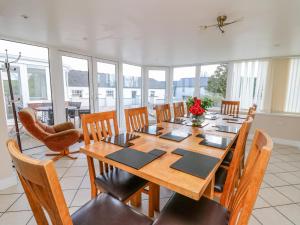 a dining room with a wooden table and chairs at Blaensilltyn in Bettws-Evan