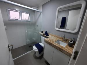 a bathroom with a toilet and a sink and a mirror at Descanse em Lindo Studio na Bela Vista em São Paulo in Sao Paulo +22 photos