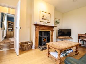 a living room with a fireplace and a table at Ferry Cottage in Sudbourne