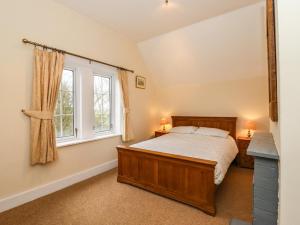 a bedroom with a bed and a window at Ferry Cottage in Sudbourne