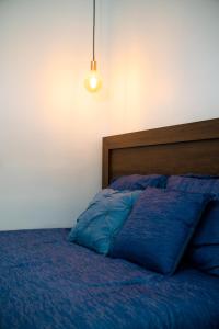 un letto con piumone blu e luce di Doral Executive Apartments a David