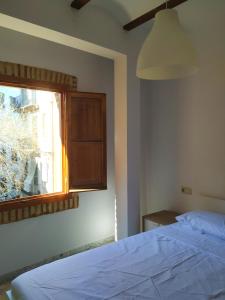 a bedroom with a white bed and a window at Apartamentos con encanto en pleno casco antiguo RON VALENCIAYOLE in Valencia