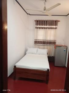 un piccolo letto in una camera con finestra di 'Franklyn', Homestay a Kalutara