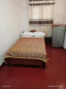 ein Schlafzimmer mit einem Bett in einem Zimmer in der Unterkunft 'Franklyn', Homestay in Kalutara