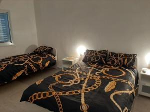 a bedroom with two beds with a chain on them at Romy suites Deluxe in Netanya