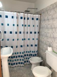 een badkamer met een toilet en een douchegordijn bij Acogedor departamento bien ubicado in Concordia