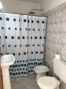 a bathroom with a toilet and a shower curtain at Acogedor departamento bien ubicado in Concordia