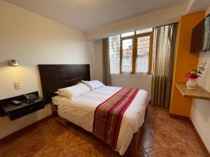 - une chambre avec un lit et une fenêtre dans l'établissement Yanapanakusun Cusco, à Cusco