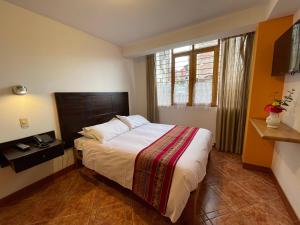 1 dormitorio con cama y ventana en Yanapanakusun Cusco, en Cusco