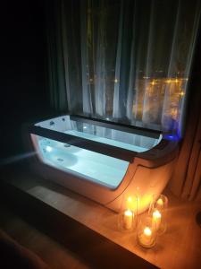 uma banheira com velas num quarto com uma janela em SPAre-Time - Exclusive and Unique Apartment! 18+ em Oradea