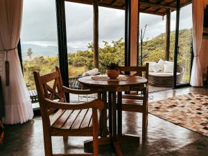 einen Tisch und Stühle in einem Zimmer mit Aussicht in der Unterkunft Pousada Viver a Pedra in Gonçalves