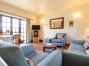 a living room with two couches and a tv at Barn Owl Cottage in Little Glenham