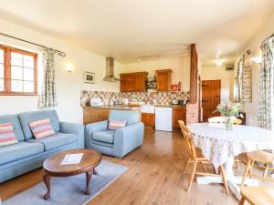 a living room with a blue couch and a table at Barn Owl Cottage in Little Glenham