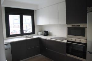 eine Küche mit schwarzen und weißen Geräten und einem Fenster in der Unterkunft La Casina de la Playa in Ribadesella + 5 Fotos