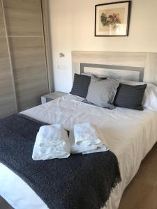 a bedroom with a large bed with towels on it at La Casina de la Playa in Ribadesella