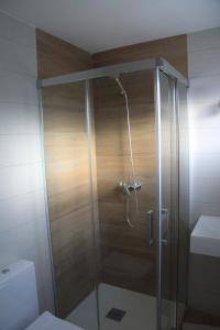 eine Dusche mit Glastür im Badezimmer in der Unterkunft La Casina de la Playa in Ribadesella