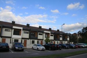 ein Parkplatz mit vor einem Gebäude geparkten Autos in der Unterkunft La Casina de la Playa in Ribadesella