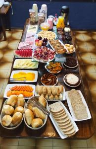 une table recouverte de beaucoup de différents types de nourriture dans l'établissement Pousada Chalé das Neves, à Gramado