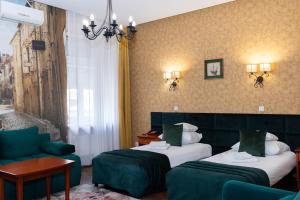 a hotel room with two beds and a couch at Hotel Wenecki in Częstochowa