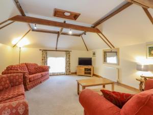 a living room with two couches and a tv at Hayloft Cottage in Little Glenham