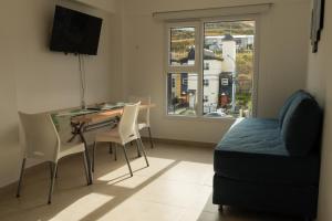 een woonkamer met een bureau, een bed en een raam bij Departamentos La Fe 2 in Ushuaia