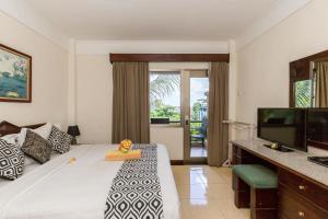 a hotel room with a bed and a television at Cozy Bali Apartment in Seminyak