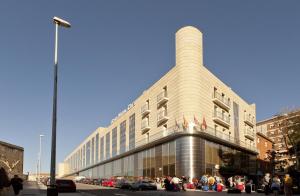 un gran edificio con gente parada fuera de él en Gran Hotel Corona Sol, en Salamanca