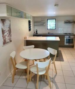 a kitchen with a table and chairs in a kitchen at Magnetic Diamond - Gorgeous Holiday Chalet in Nelly Bay
