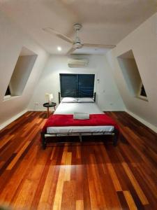 um quarto com uma cama grande num quarto com pisos em madeira em Magnetic Diamond - Gorgeous Holiday Chalet em Nelly Bay