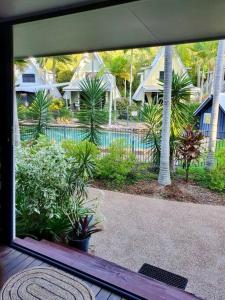 Blick auf den Pool von einem Fenster des Hauses in der Unterkunft Magnetic Diamond - Gorgeous Holiday Chalet in Nelly Bay